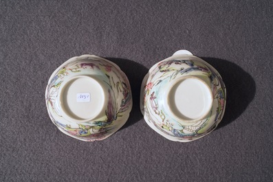 A pair of Chinese famille rose cups and saucers with figures in a landscape, Yongzheng